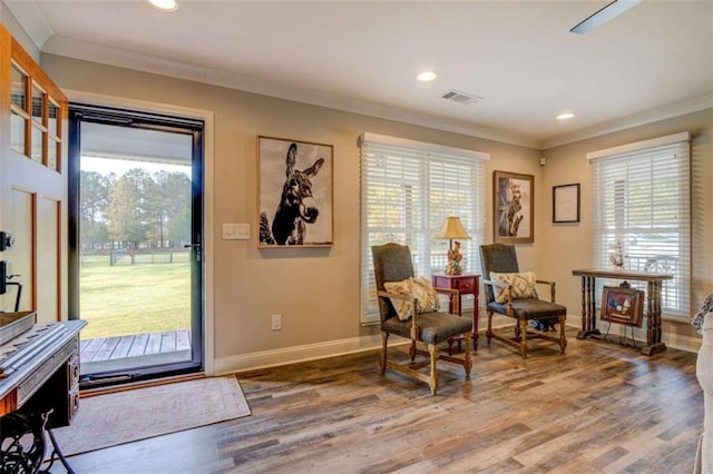 living area featuring hardwood / wood-style floors and ornamental molding