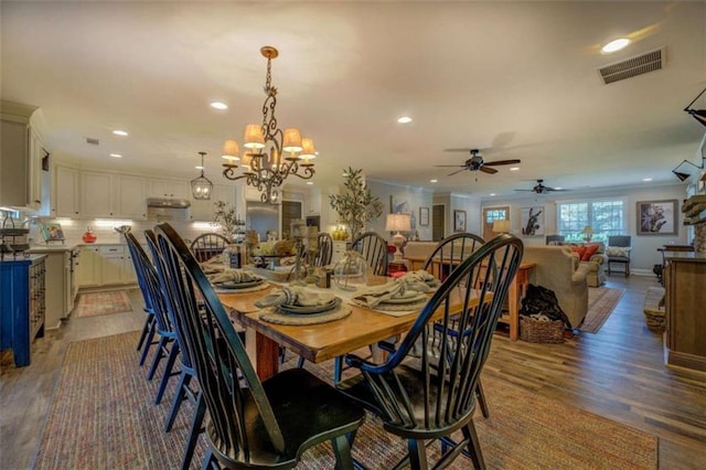 dining area with a chandelier, ornamental molding, and dark hardwood / wood-style flooring