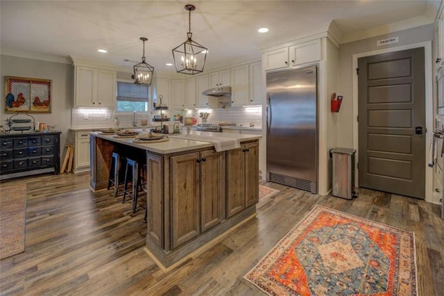 kitchen featuring a kitchen island, white cabinets, pendant lighting, and stainless steel appliances