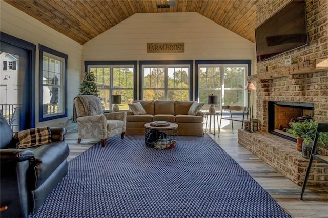 sunroom / solarium with wooden ceiling, an outdoor brick fireplace, and vaulted ceiling