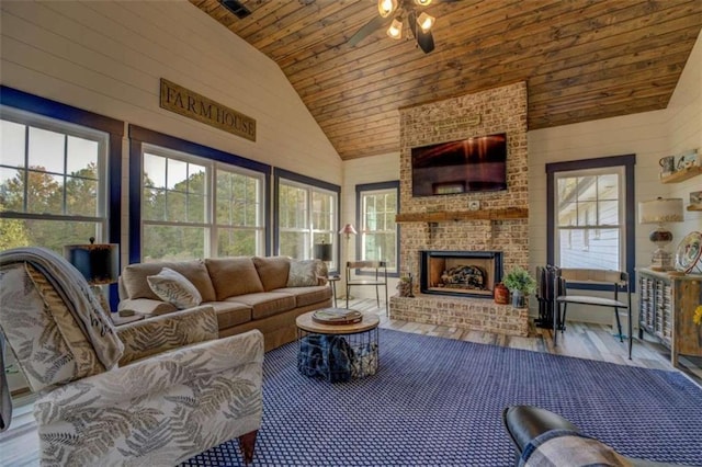 living room with wood-type flooring, ceiling fan, high vaulted ceiling, wooden ceiling, and an outdoor brick fireplace