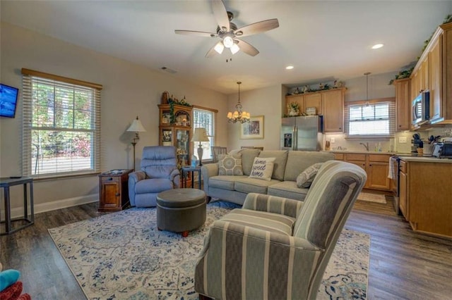 living room with sink, ceiling fan with notable chandelier, a healthy amount of sunlight, and dark hardwood / wood-style floors