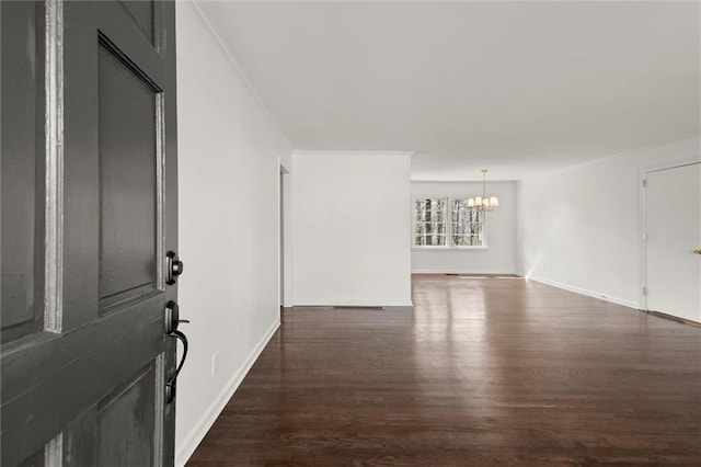 interior space featuring an inviting chandelier, baseboards, dark wood finished floors, and crown molding