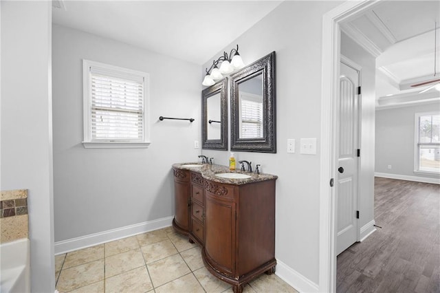 bathroom featuring double vanity, baseboards, and a sink