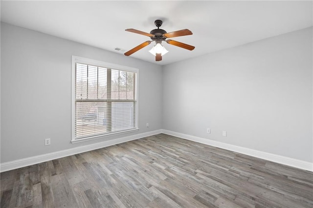 empty room featuring visible vents, baseboards, and wood finished floors