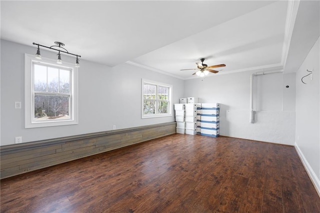 empty room with ornamental molding, baseboards, ceiling fan, and wood finished floors