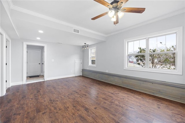 spare room with wood finished floors, visible vents, baseboards, ceiling fan, and crown molding