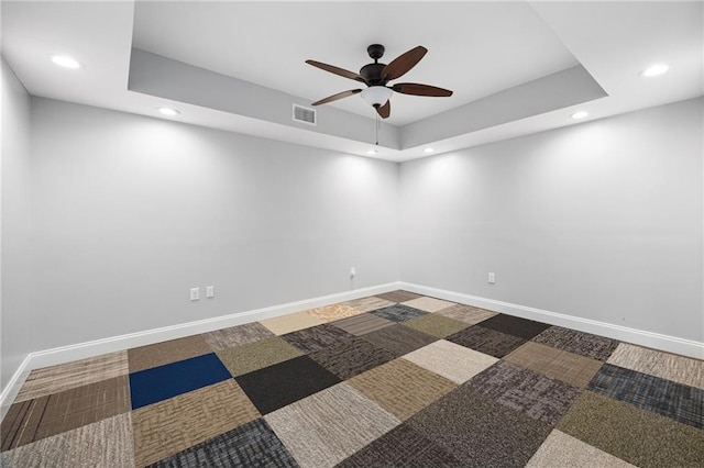 carpeted spare room featuring a raised ceiling, recessed lighting, baseboards, and visible vents