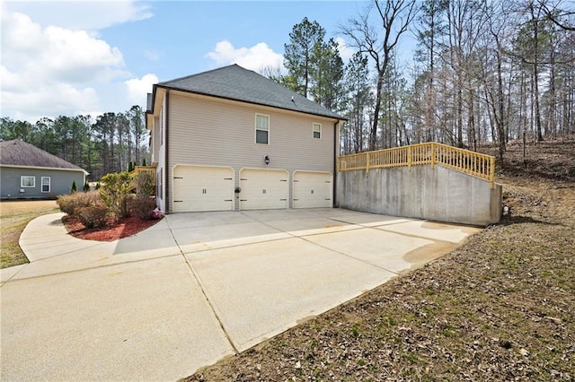 view of side of home featuring driveway and an attached garage