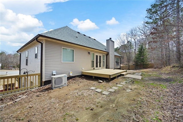 back of property with roof with shingles, a chimney, french doors, a deck, and ac unit