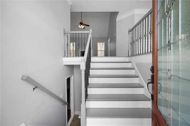 staircase with ceiling fan and crown molding