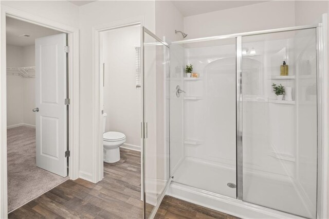 204 Epping St Unit 2, Stockbridge, GA 30281 - full bathroom with toilet, a stall shower, baseboards, wood finished floors, and a spacious closet