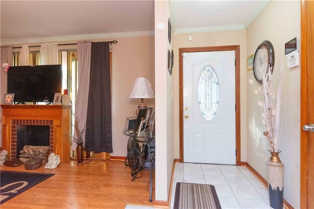 entrance foyer with light hardwood / wood-style floors, crown molding, and a brick fireplace