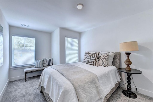 carpeted bedroom featuring baseboards and visible vents