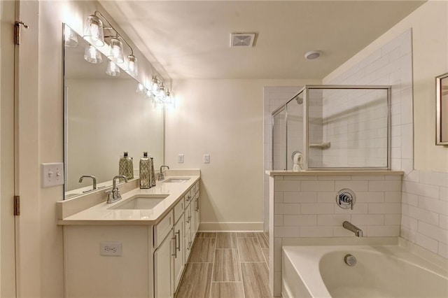 bathroom with visible vents, a sink, a garden tub, and tiled shower