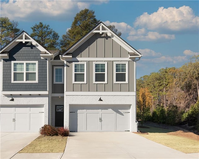 view of front facade with concrete driveway, brick siding, board and batten siding, and an attached garage