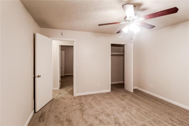 unfurnished bedroom with a closet, light colored carpet, and ceiling fan