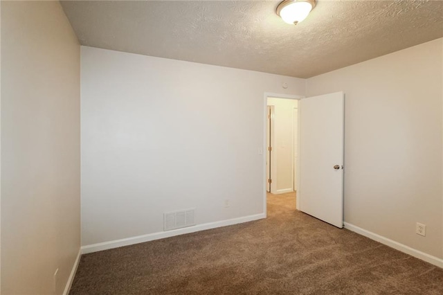 empty room with a textured ceiling and carpet