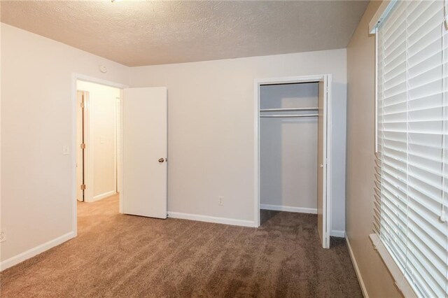 unfurnished bedroom featuring a closet, a textured ceiling, and carpet floors