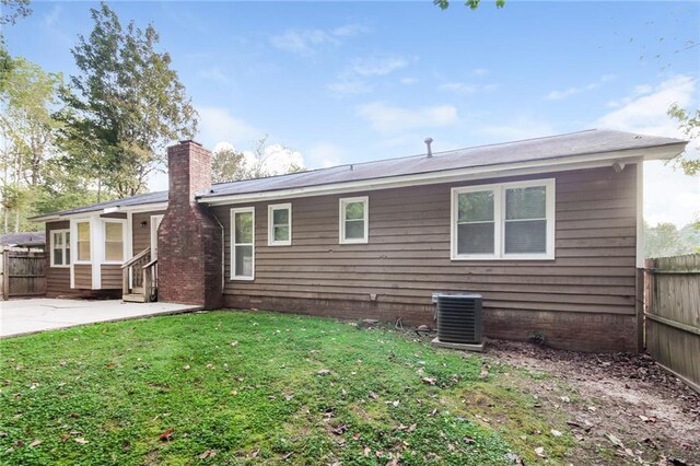 rear view of house featuring a yard, a patio area, and central AC unit