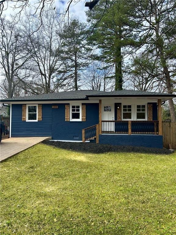 ranch-style house featuring driveway, covered porch, fence, and a front yard