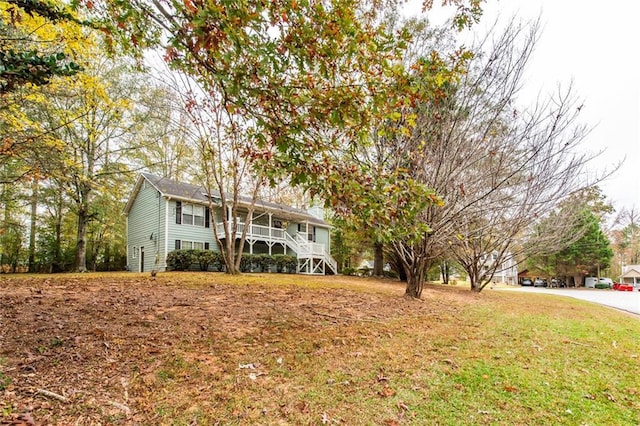 raised ranch featuring stairway and a front yard