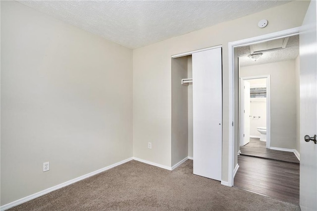 unfurnished bedroom featuring carpet flooring, a textured ceiling, and a closet