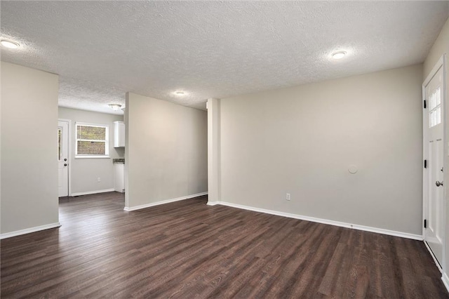 empty room featuring dark wood-type flooring and a textured ceiling