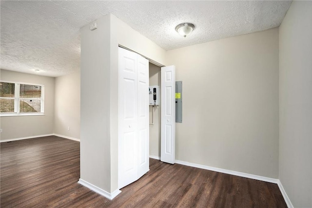 hall with dark hardwood / wood-style floors and a textured ceiling