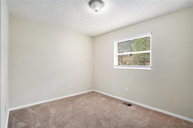 carpeted spare room with a textured ceiling