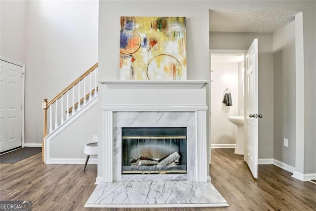 5 Corbel Way, Newnan, GA 30265 - detailed view of wood finished floors, a high end fireplace, baseboards, and a textured ceiling