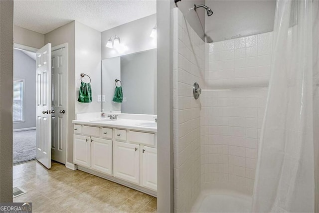 5 Corbel Way, Newnan, GA 30265 - bathroom featuring a tile shower, double vanity, a textured ceiling, and tile patterned floors