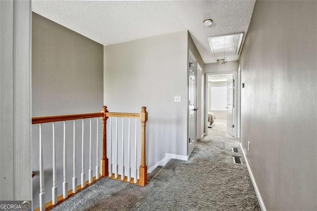 5 Corbel Way, Newnan, GA 30265 - hallway featuring attic access, an upstairs landing, carpet floors, baseboards, and a textured ceiling