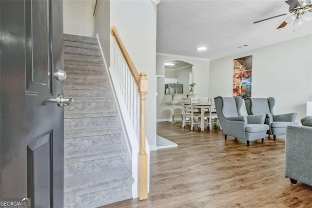 5 Corbel Way, Newnan, GA 30265 - staircase featuring a ceiling fan, wood finished floors, a textured ceiling, and arched walkways