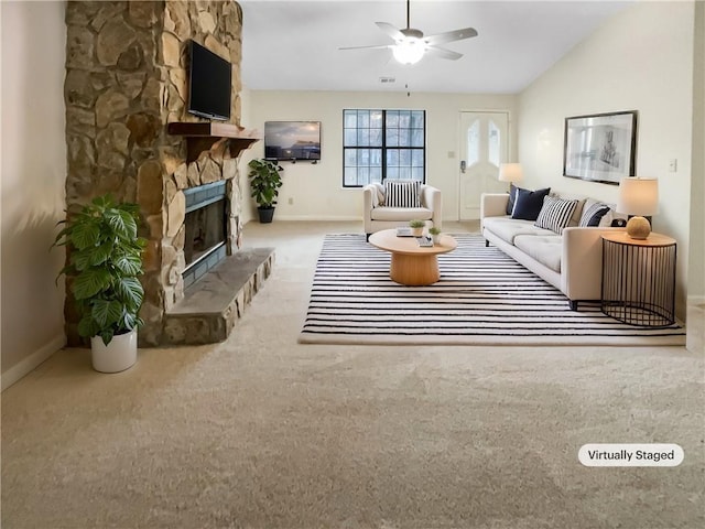 living area featuring lofted ceiling, a fireplace, a ceiling fan, baseboards, and carpet