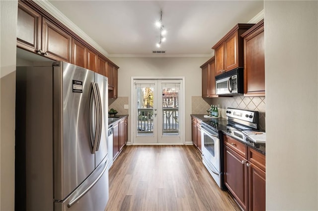 kitchen featuring light wood-style flooring, ornamental molding, tasteful backsplash, stainless steel appliances, and french doors