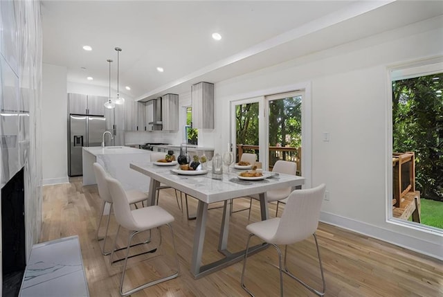 dining room featuring a wealth of natural light, light wood-style flooring, and recessed lighting