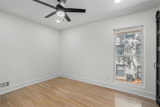 empty room with visible vents, baseboards, a ceiling fan, and light wood finished floors