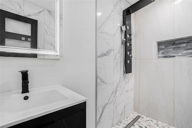 bathroom with vanity and a marble finish shower