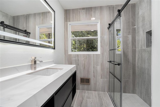 bathroom with vanity, a shower stall, and visible vents