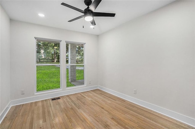 spare room with light wood-type flooring, baseboards, visible vents, and ceiling fan