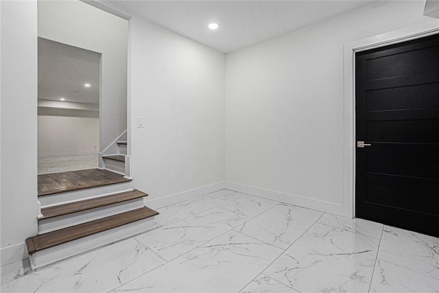 spare room with recessed lighting, baseboards, marble finish floor, and stairs