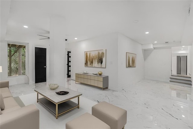 living area with recessed lighting, marble finish floor, and baseboards