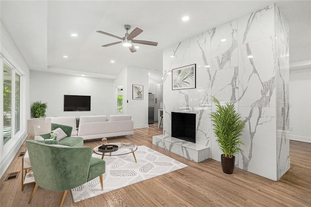 living room with visible vents, recessed lighting, a fireplace, wood finished floors, and a ceiling fan