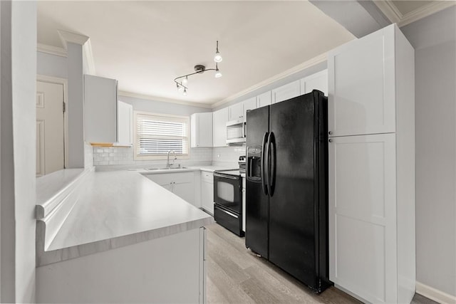 kitchen featuring tasteful backsplash, white cabinets, ornamental molding, and black appliances