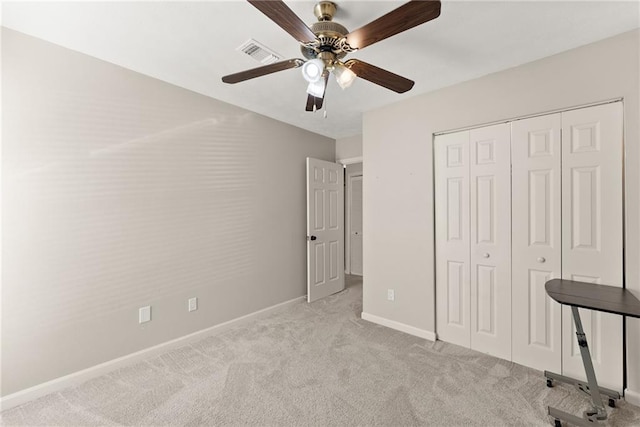 unfurnished bedroom featuring light colored carpet, ceiling fan, and a closet