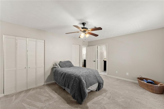 carpeted bedroom featuring ceiling fan and two closets