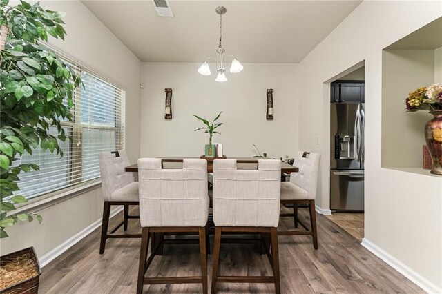 dining room with a chandelier and dark wood-type flooring