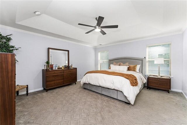 carpeted bedroom featuring ceiling fan, crown molding, and a tray ceiling