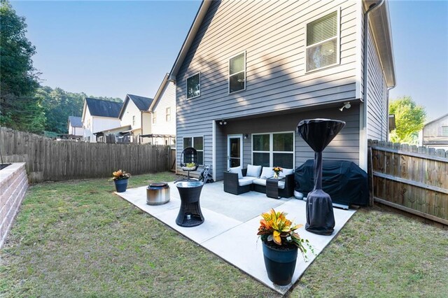 back of house featuring outdoor lounge area, a patio, and a lawn